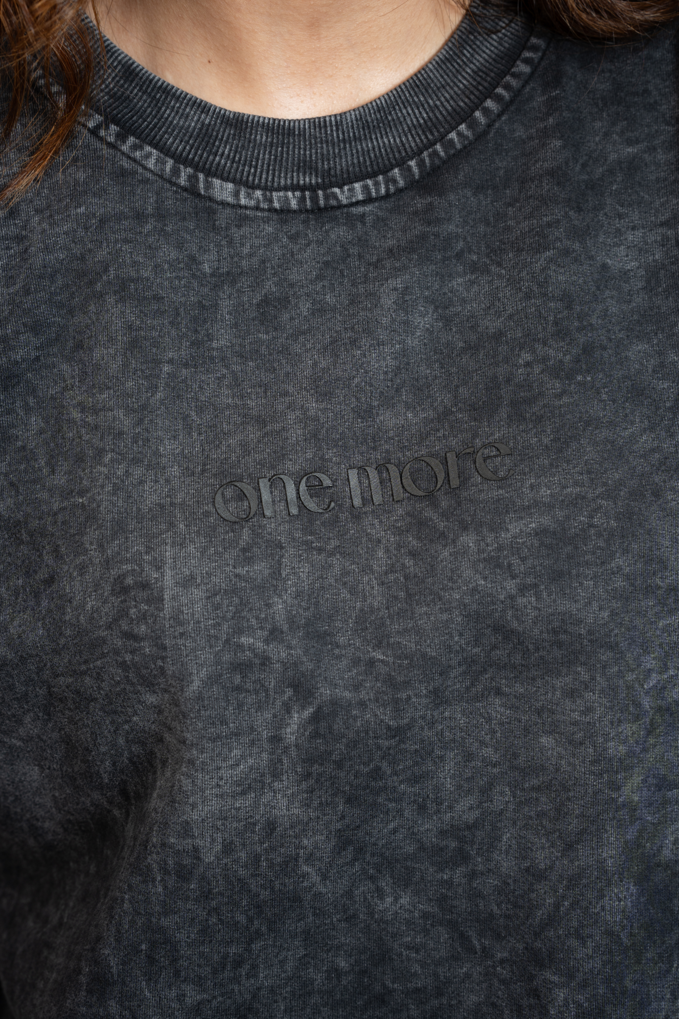 Dark gray tee with 'ONE MORE' text on a blurred background