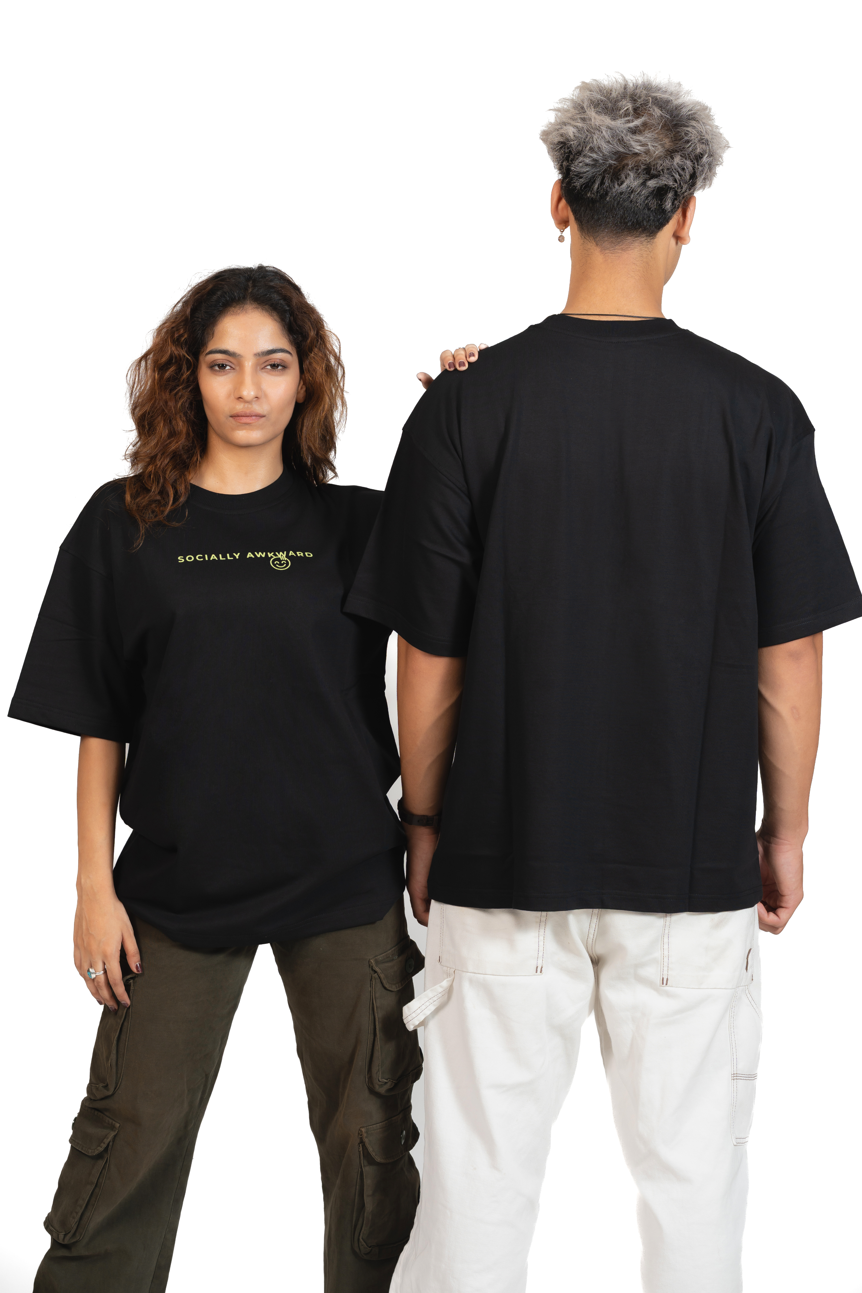 Two people wearing black t-shirts with text 'socially awkward' written on the front in yellow, one facing forward and the other facing backward.